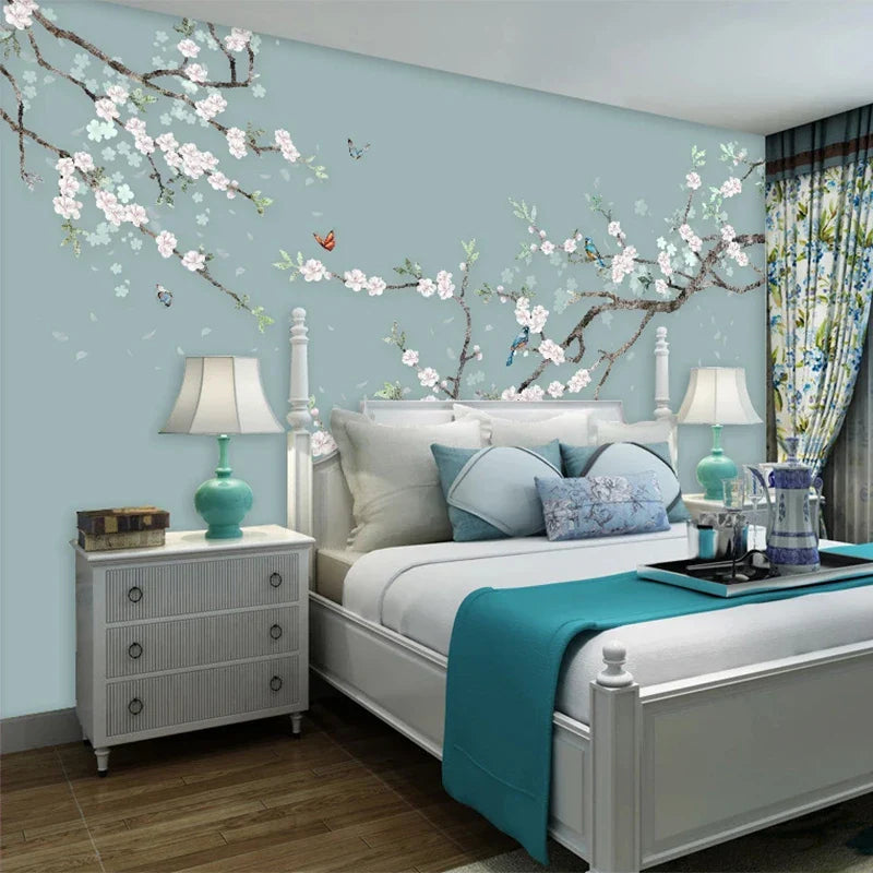 Slaapkamer met witte bed en muur met delicate bloemen en sierlijke vogels in blauwe achtergrond