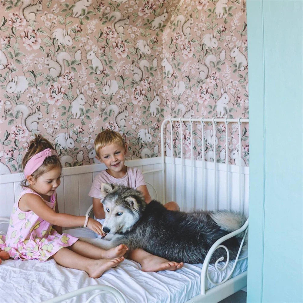 Een hond op een bed met twee kinderen.