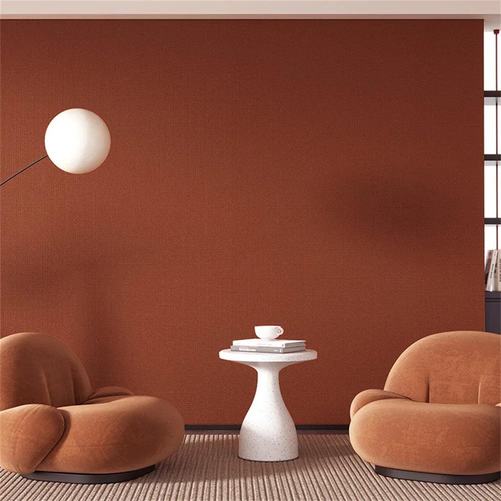 Twee ronde, pluche fauteuils in een warme terracotta kleur.